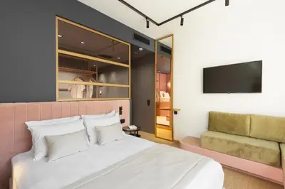 a bedroom with a bed and a flatscreen tv at COLORS Hotel Athens in Athens