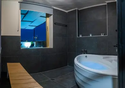a bathroom with a tub and a toilet and a window at NOHO Boutique , premium living Lazeon 7 in Athens