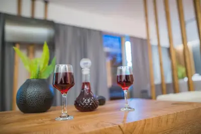 two glasses of red wine sitting on a wooden table at NOHO Boutique , premium living Lazeon 7 in Athens