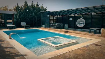 a swimming pool in the middle of a yard at Olivujoj Villajoj - Deluxe Villa with Detached Pool House in Anavissos