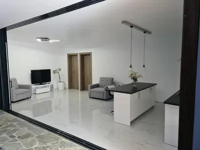 a large living room with a tv and a large mirror at Olivujoj Villajoj - Deluxe Villa with Detached Pool House in Anavissos