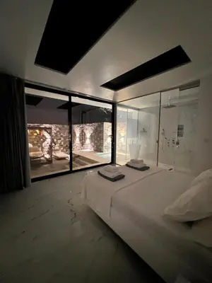 a bedroom with a large bed with a large window at Olivujoj Villajoj - Deluxe Villa with Detached Pool House in Anavissos