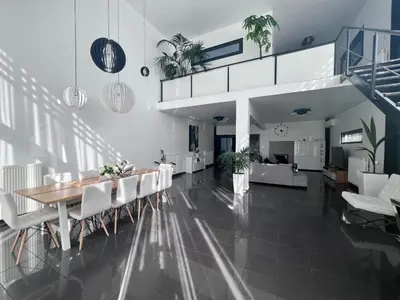a dining room and living room with a table and chairs at Olivujoj Villajoj - Deluxe Villa with Detached Pool House in Anavissos