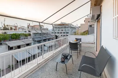 a balcony with chairs and a table on a building at Athens Acropolis House in Athens
