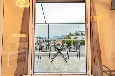 a glass door leading to a balcony with a table and chairs at Athens Acropolis House in Athens