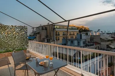 a patio with a table and chairs on a balcony at Athens Acropolis House in Athens