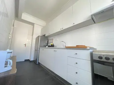 a kitchen with white cabinets and a stainless steel refrigerator at Plato - Acropolis Residence Apartment in Athens