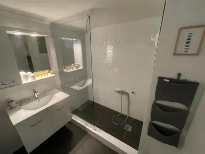 a bathroom with a glass shower and a sink at Plato - Acropolis Residence Apartment in Athens