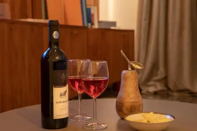 a bottle of wine and two glasses on a table at Plato - Acropolis Residence Apartment in Athens