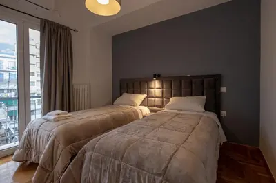 two beds in a bedroom with a large window at Plato - Acropolis Residence Apartment in Athens
