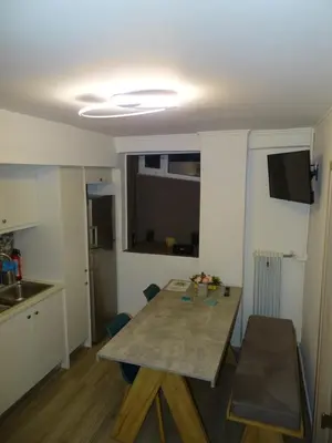 a room with a table and a kitchen with a window at Stylish, comfortable, basement loft-like apartment with amenities in Athens