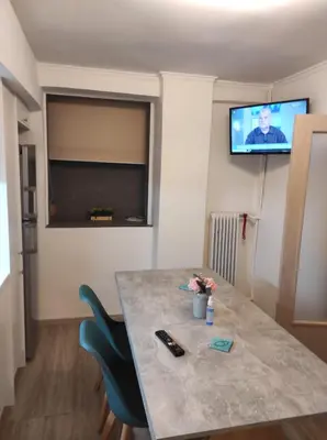 a room with a table with two chairs and a television at Stylish, comfortable, basement loft-like apartment with amenities in Athens