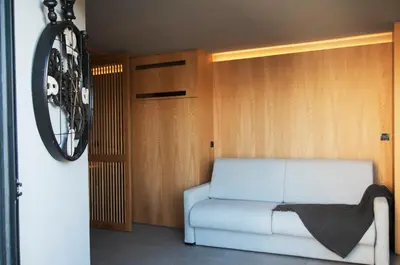 a living room with a white couch and wooden walls at Groovy in Athens