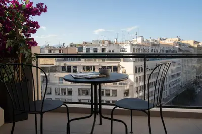 a table and chairs on a balcony with a view at Groovy in Athens