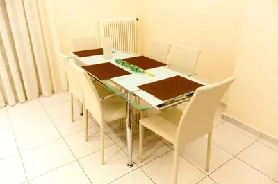 a dining room table with white chairs around it at Acropolis view and 360 degrees in Athens