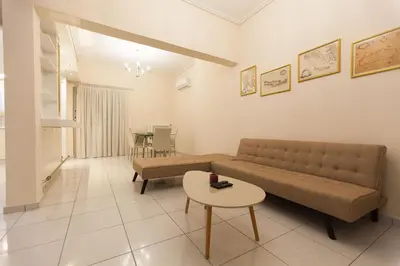 a living room with a couch and a table at Acropolis view and 360 degrees in Athens