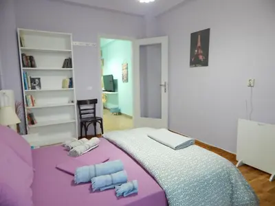 a bedroom with a purple bed with two towels at Feels Like Home 2 in Athens