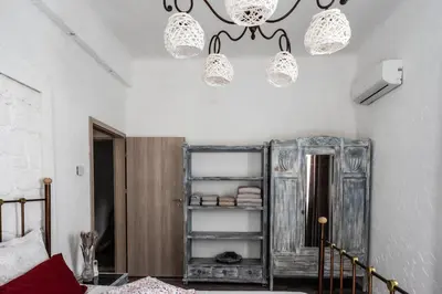 a bedroom with two chandeliers and a room with a bed at Unique Luxury House in Athens