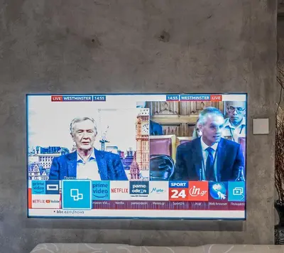 a television screen with a picture of a man at Unique Luxury House in Athens