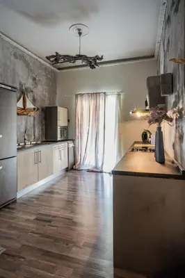 a kitchen with wooden floors and a large window at Unique Luxury House in Athens