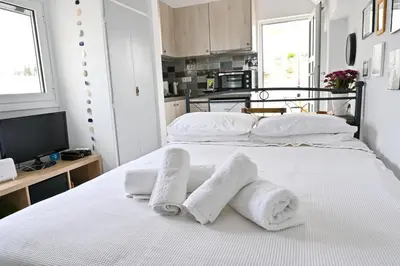 a bedroom with a white bed with towels on it at Top of the city Central studio with Acropolis View in Athens