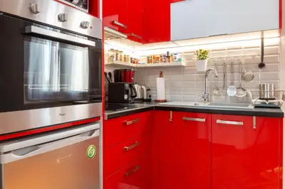 a red kitchen with red cabinets and a sink at Martin's Akropolis Studio in Athens