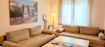 a living room with a couch and a table at Acropolis museum grand apartment in Athens