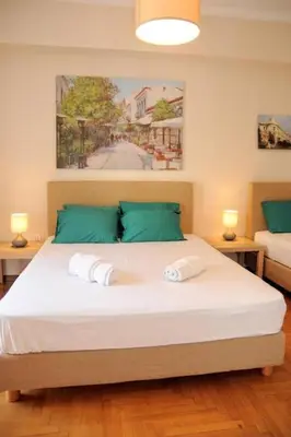 a bedroom with a large white bed with green pillows at Acropolis museum grand apartment in Athens