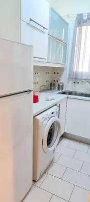 a kitchen with a washing machine and a refrigerator at Acropolis museum grand apartment in Athens