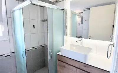 a bathroom with a sink and a shower and a mirror at Acropolis museum grand apartment in Athens