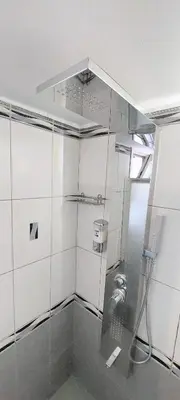 a bathroom with a shower with a glass wall at Acropolis museum grand apartment in Athens