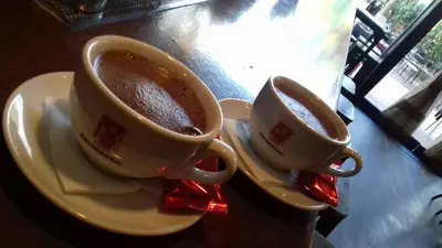 two cups of coffee on plates on a table at Rooster Suites in Athens