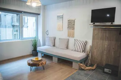 a living room with a couch and a tv at Rooster Suites in Athens