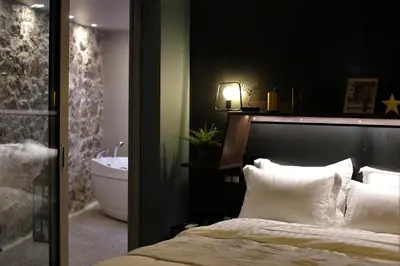 a bedroom with a bed and a bath tub and a sink at Rooster Suites in Athens