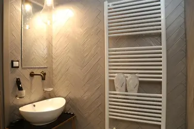 a bathroom with a white sink and a mirror at Rooster Suites in Athens