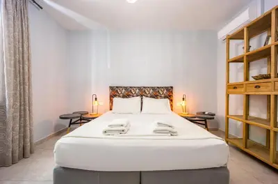 a large white bed in a room with two tables at Bentzi...Boutique Apartment in Pangrati, Superior Suite (2) for 4 guests in Athens