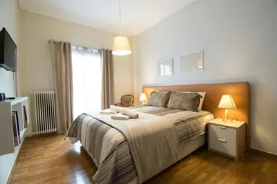 a bedroom with a large bed and a window at Relaxing by Acropolis in Athens