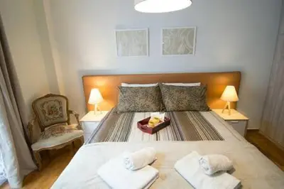 a bedroom with a large bed and a chair at Relaxing by Acropolis in Athens