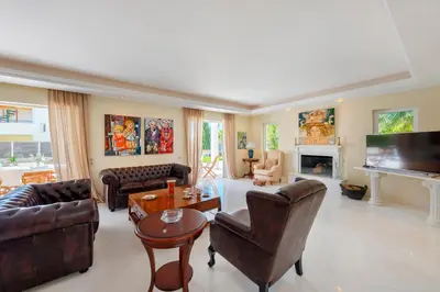 a living room with leather furniture and a fireplace at The Painters Luxurious villa in Anavissos