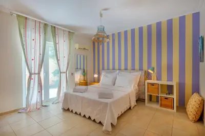 a bedroom with a bed and a striped wall at The Painters Luxurious villa in Anavissos