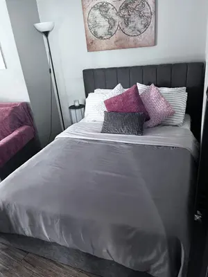 a bed with purple and white pillows on it at Cozy studio apartment in the heart of Athens in Athens
