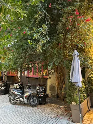 a motorcycle parked under a tree with an umbrella at Cozy studio apartment in the heart of Athens in Athens