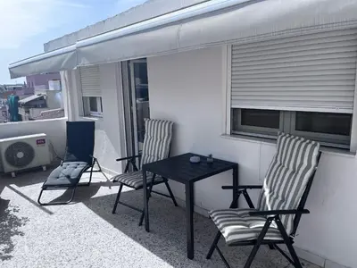 a patio with two chairs and a table on a balcony at Cozy studio apartment in the heart of Athens in Athens