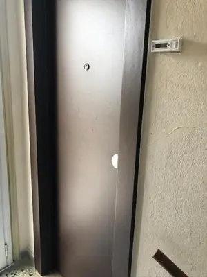 a brown door with a button on it next to a wall at Cozy studio apartment in the heart of Athens in Athens