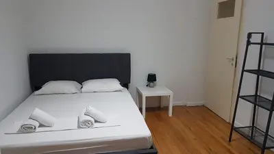 a bedroom with a white bed with a black headboard at Olive Apartment- Athens Center, 4 BD, 1.5 BATH in Athens