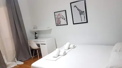 a white bedroom with a white bed and a desk at Olive Apartment- Athens Center, 4 BD, 1.5 BATH in Athens