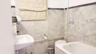 a small bathroom with a sink and a toilet at Olive Apartment- Athens Center, 4 BD, 1.5 BATH in Athens