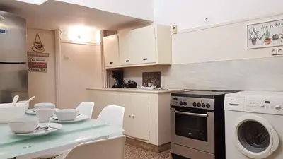 a kitchen with a stove and a table with chairs at Olive Apartment- Athens Center, 4 BD, 1.5 BATH in Athens