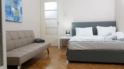 a bedroom with a bed and a couch at Olive Apartment- Athens Center, 4 BD, 1.5 BATH in Athens