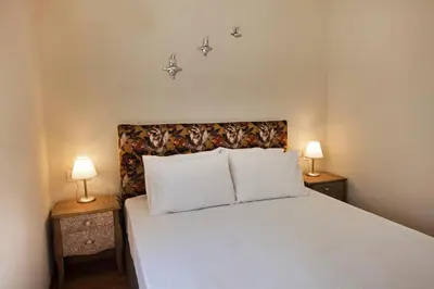 a bedroom with a white bed with two lamps at Bentzi Boutique Apartment 4 in Athens